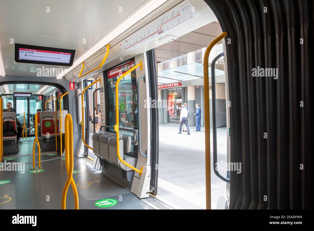 Interior Sydney light rail train with covid 19 stand here green signs on the floor,Sydney,NSW,Australia Stock Photo