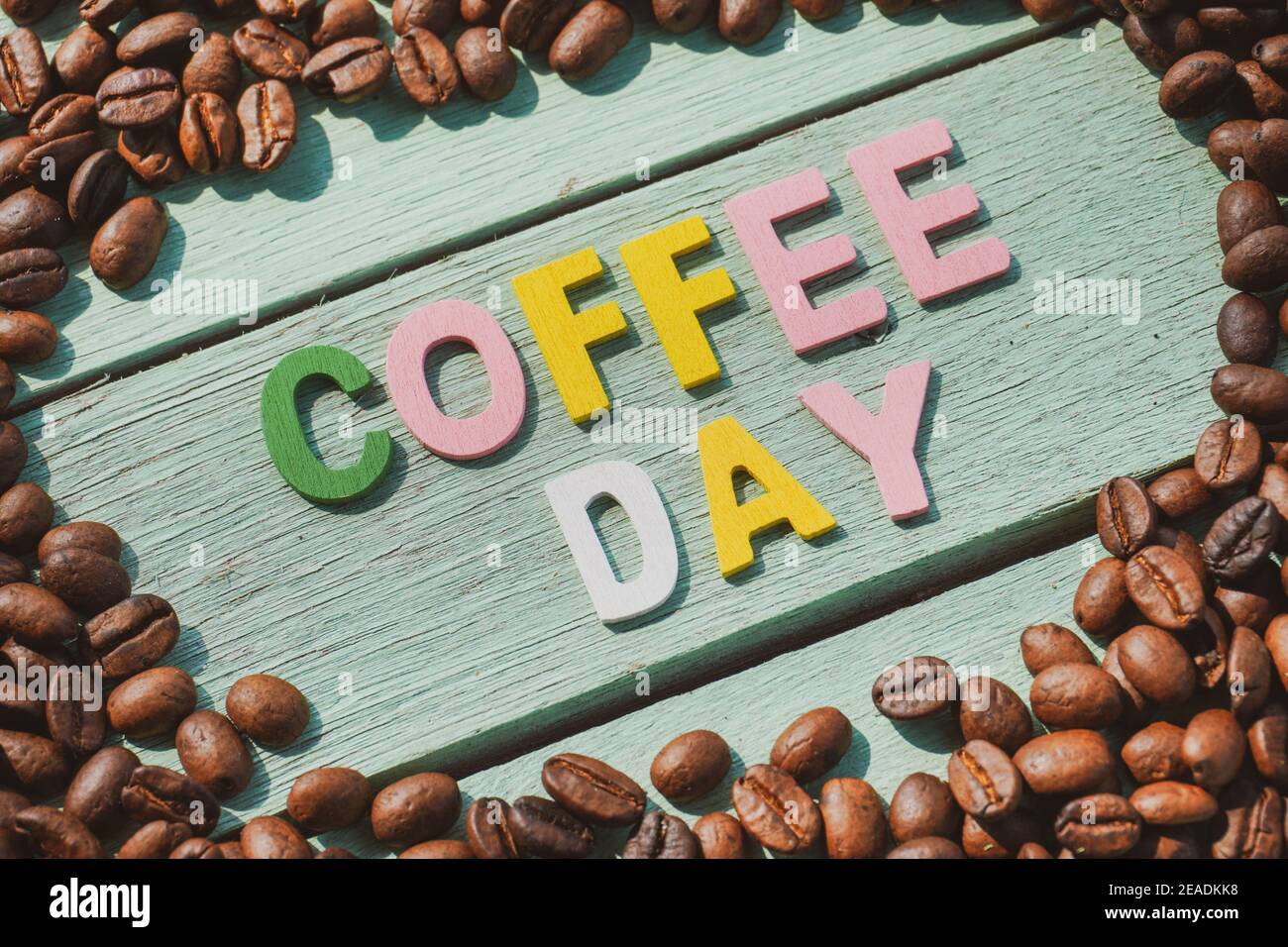 Coffee Day alphabets form on roasted coffee beans background Stock