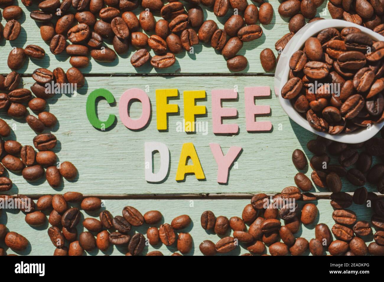 Coffee Day alphabets form on roasted coffee beans background. Stock Photo