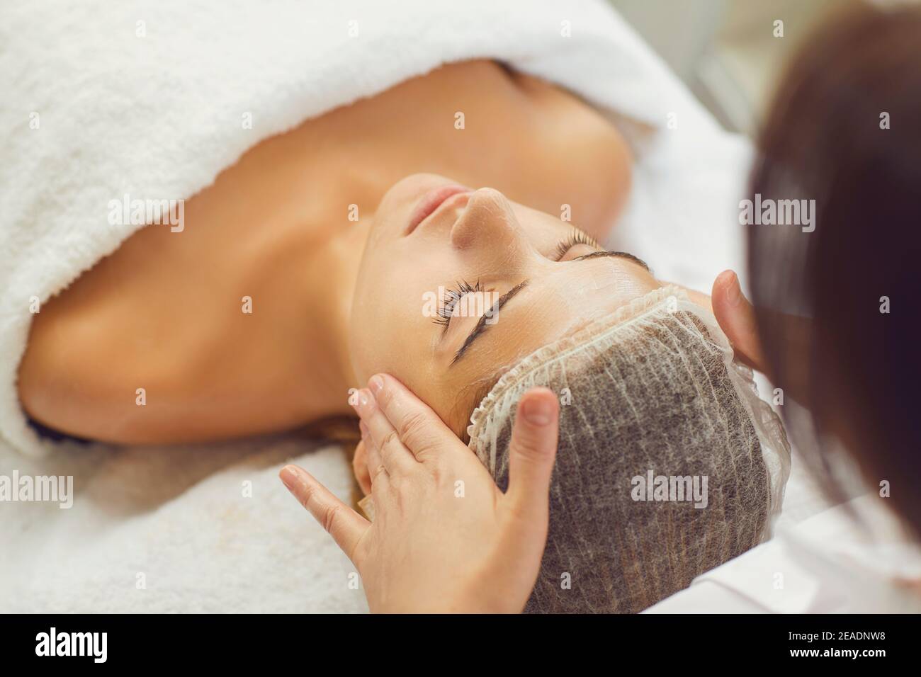 Face massage. Close-up of young woman getting spa massage treatment at beauty spa salon. Stock Photo