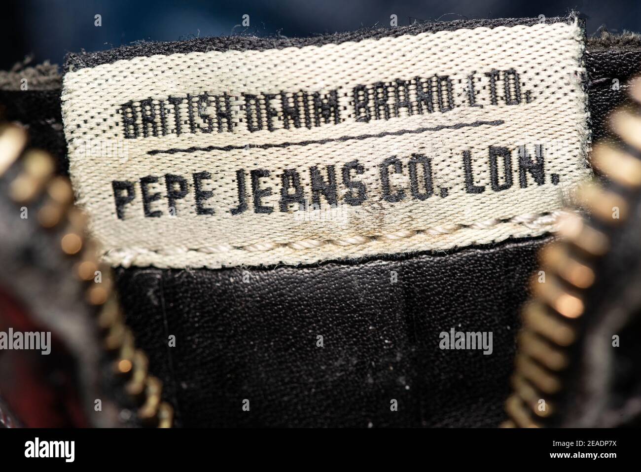 British Denim Brand Ltd. Pepe Jeans Co. London worn out shoe label on black leather men's boots close up detail Stock Photo