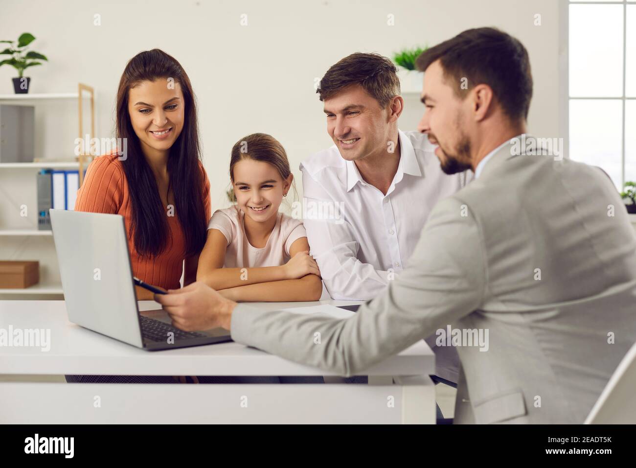Happy family meeting with real estate agent and discussing house purchase details Stock Photo