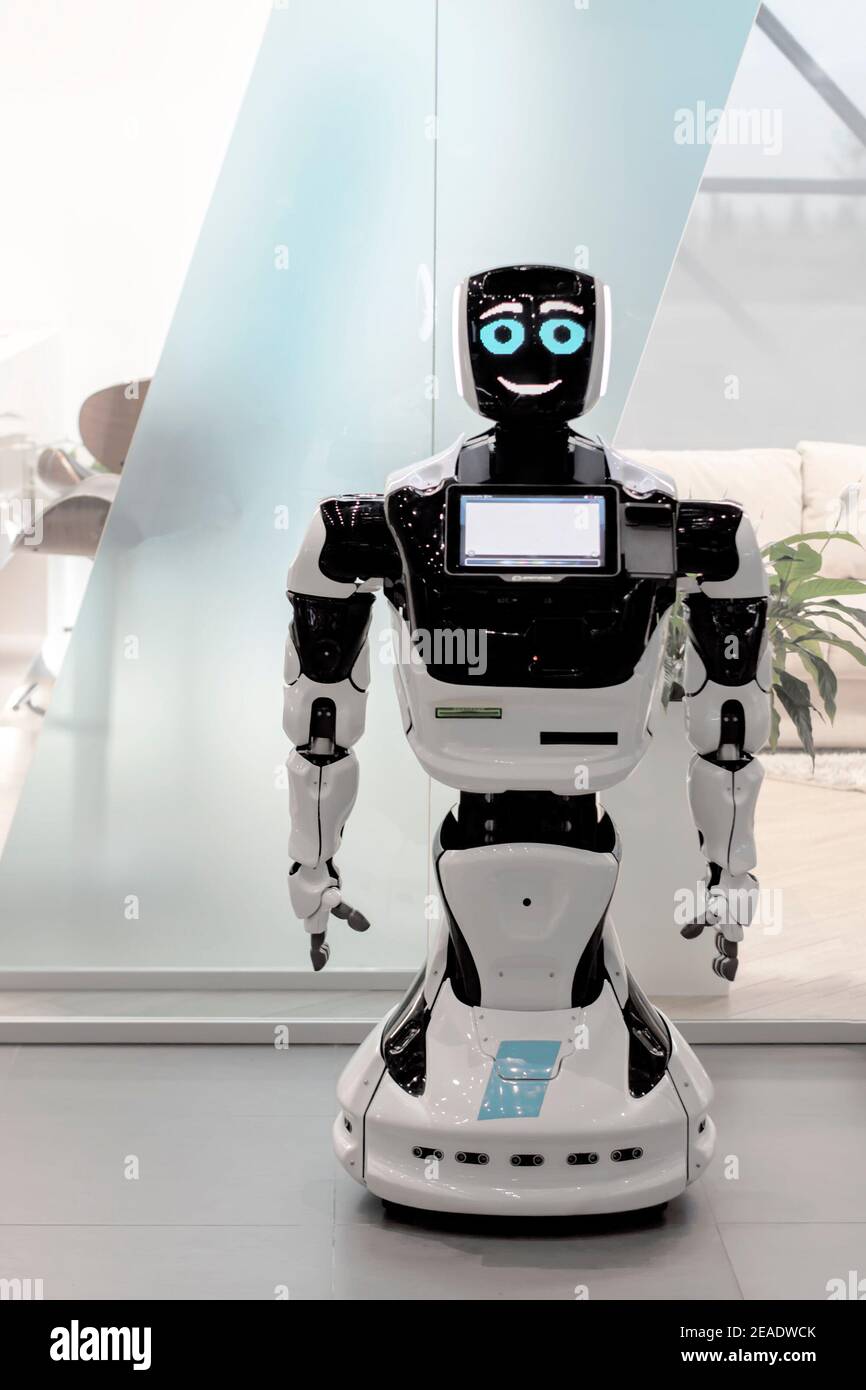 White Robot droid assistant in the office. View from the front. It's a  bright room. Soft focus Stock Photo - Alamy