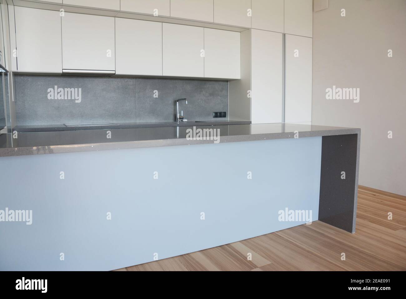 Modern Minimalist Kitchen Design With White Cabinets Range Hood Built In Refrigerator Gray Countertop With A Sink And Electric Stove Cooktop And A Stock Photo Alamy