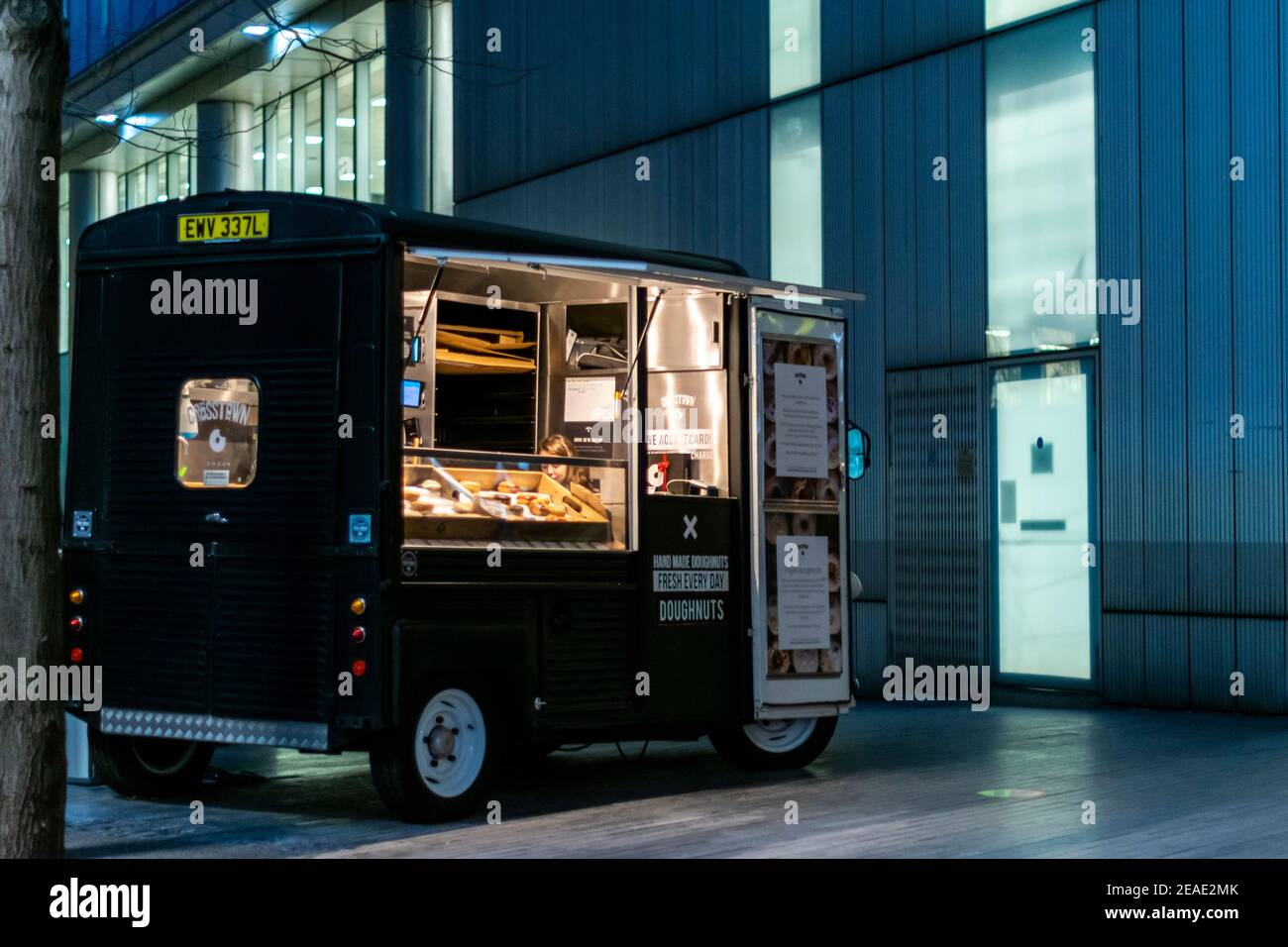 London, UK- 15 Dec 2020: Dognut food truck parked in central London nearby of the Shard building. Young girl waiting for customers to sell donuts in a Stock Photo