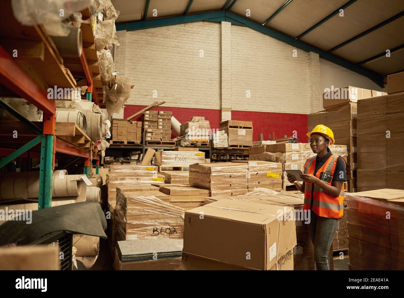 African female warehouse worker checking inventory with a digital tablet Stock Photo