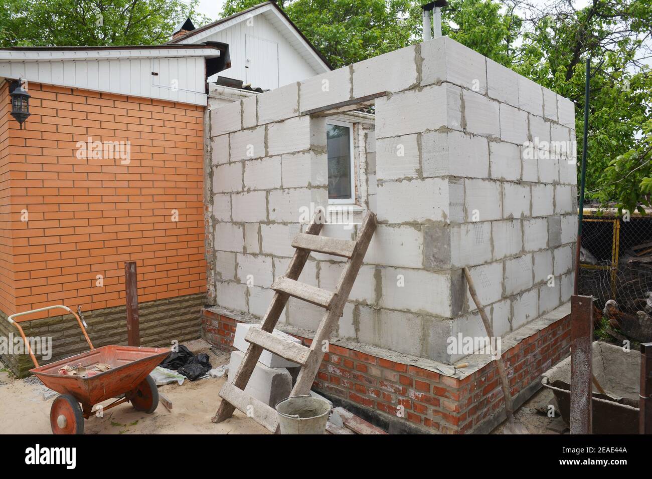 Building a home addition from aerated autoclaved concrete blocks to a brick house. Stock Photo