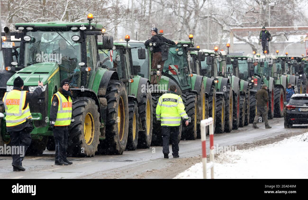 Stralsund, Germany. 09th Feb, 2021. Under police supervision, farmers protest against new environmental regulations with a parade of 206 tractors to the district administration office of Vorpommern-Rügen. The reason for the protest is the 'Action Programme for Insect Protection' planned by the Federal Government, which is to be adopted by the Federal Cabinet on 09.02.2021. Credit: Bernd Wüstneck/dpa-Zentralbild/dpa/Alamy Live News Stock Photo