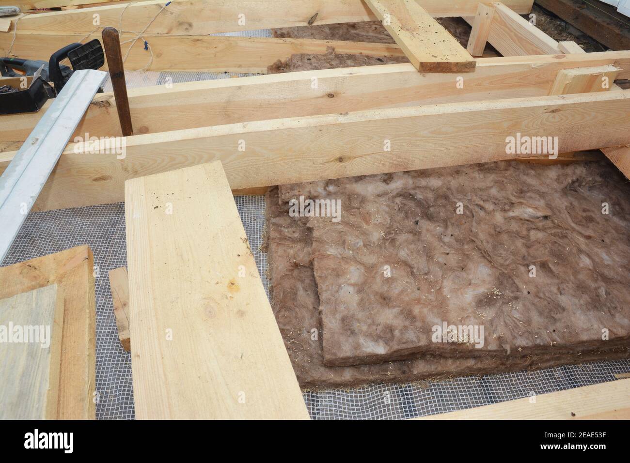 A closeup on roof, attic thermal fiberglass, mineral glass wool insulation under wooden roof