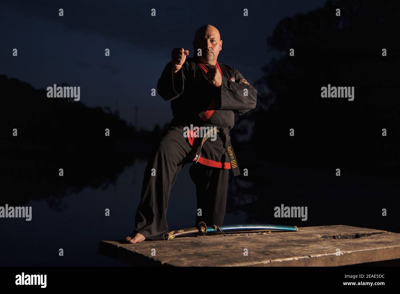 Sipalkido master at night with katana and read and black uniform Stock Photo