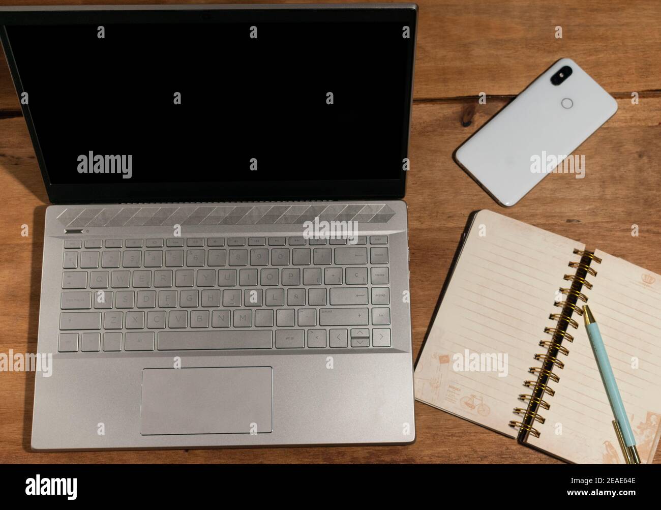 laptop on wooden table with mobile and notebook Stock Photo