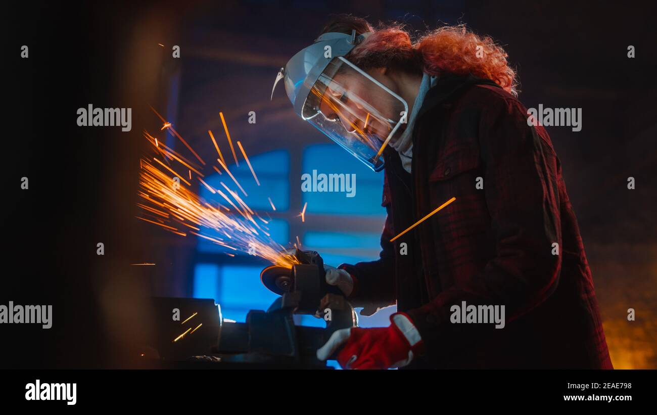 Talented Female Fabricator Uses an Angle Grinder to Polish a Circular Metal Object. The Ring is Gripped in a Bench Vise. Beautiful Tomboy Engineer Stock Photo