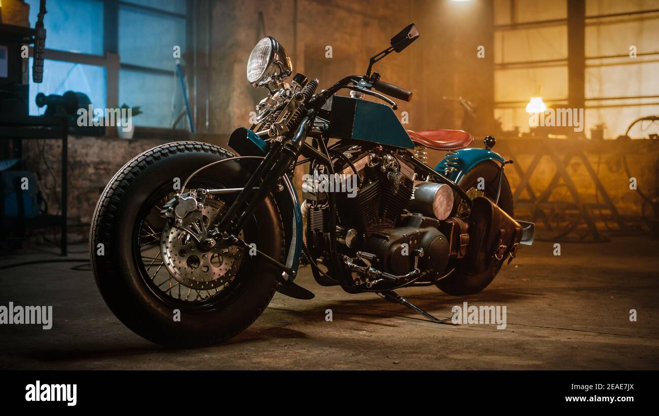 https://c8.alamy.com/comp/2EAE7JX/custom-bobber-motorbike-standing-in-an-authentic-creative-workshop-vintage-style-motorcycle-under-warm-lamp-light-in-a-garage-2EAE7JX.jpg