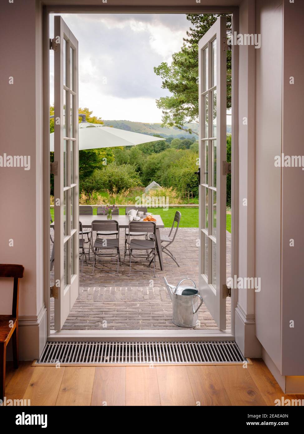Open French windows leading to a seating area on the terrace of a contemporary home in Sussex, UK Stock Photo