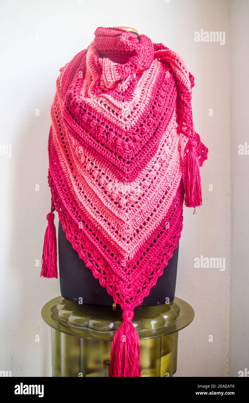 Elegant red and pink poncho or shawl tied by a young smiling and happy