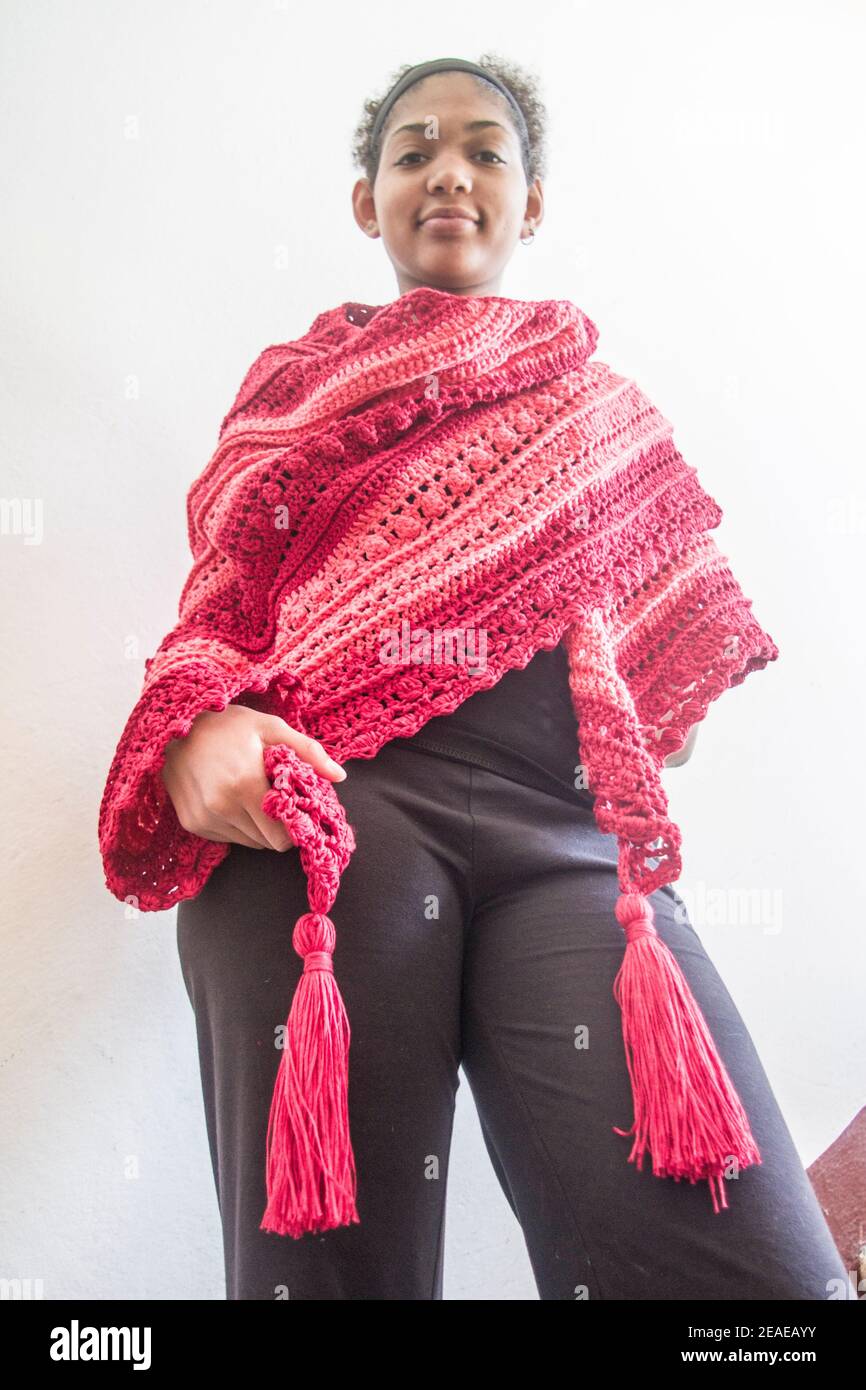 Elegant red and pink poncho or shawl tied by a young smiling and happy