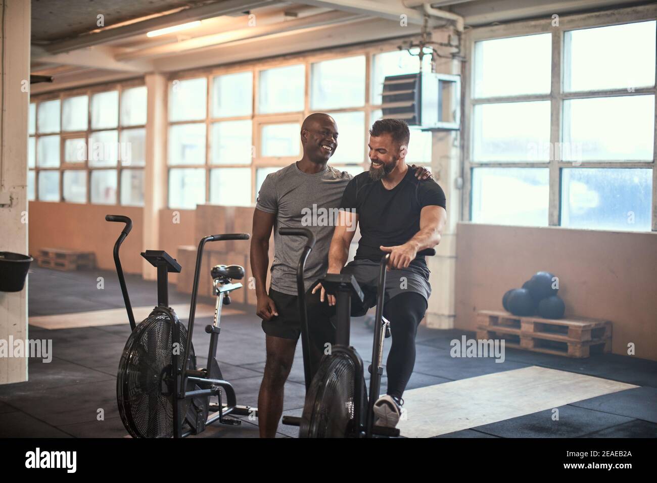 Two fit young men laughing after a cardio workout session together