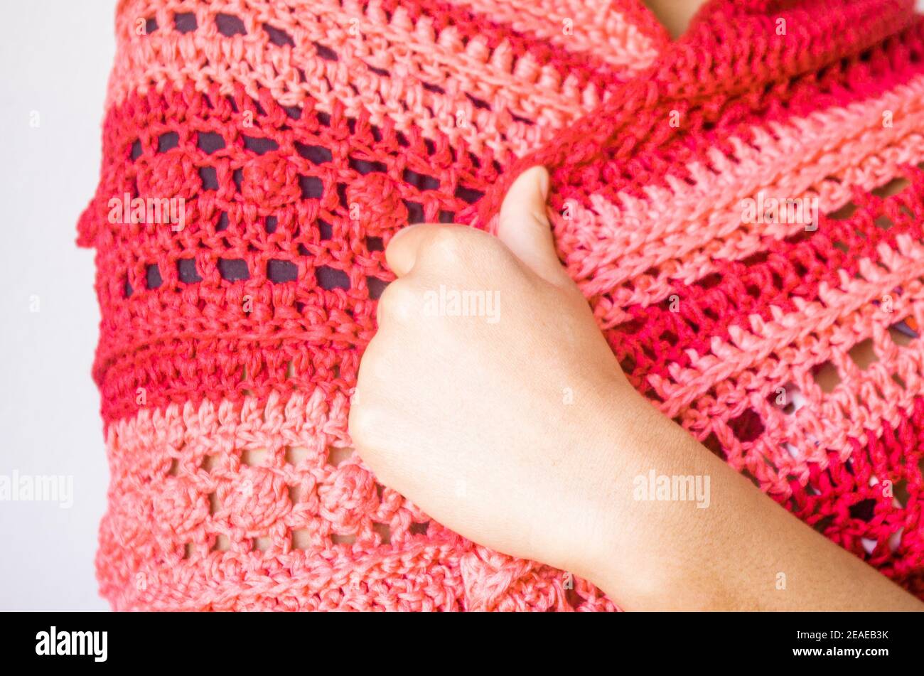 Elegant red and pink poncho or shawl tied by a young smiling and happy