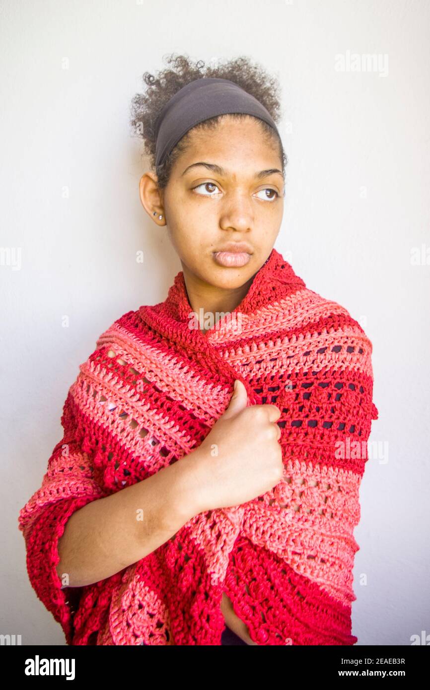 Elegant red and pink poncho or shawl tied by a young smiling and happy