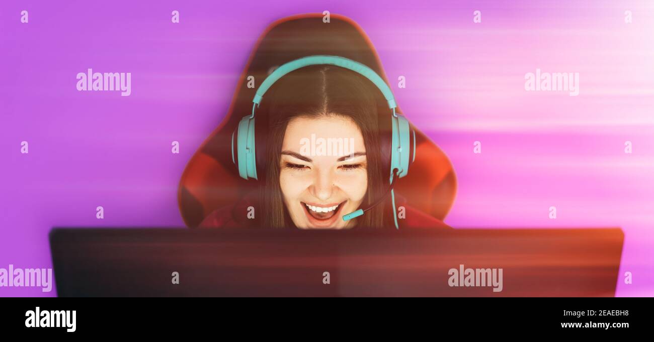 The gamer sits on a gaming chair and plays computer games. The player has  birch-colored headphones on his head Stock Photo - Alamy
