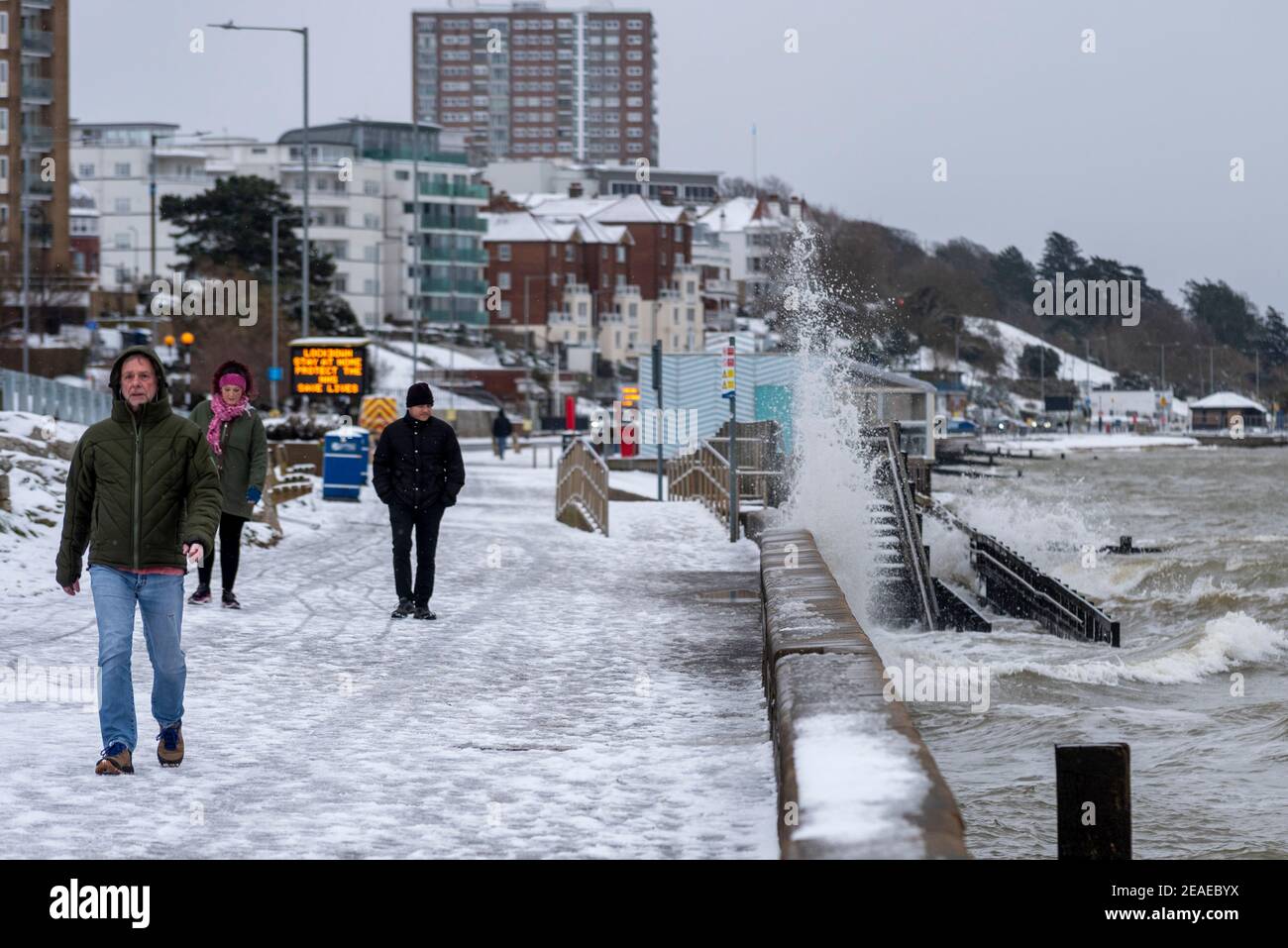 Southend on Sea, Essex, UK. 9th Feb, 2021. Storm Darcy has dropped further snow on the seafront, and brought icy and windy conditions.  Walkers braved the cold winds and crashing waves along the frozen icy Western Esplanade Stock Photo