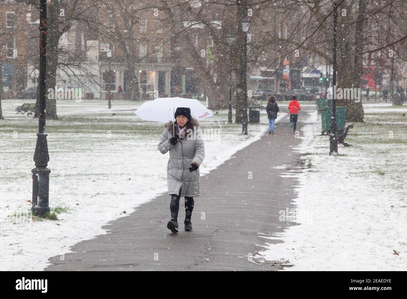 London, UK. 9 February 2021: After three days of snow in London it is starting to settle and winds have dropped as Storm Darcy has passed. On Clapham Common a few people take exercise. Credit: Anna Watson/Alamy Live News Stock Photo