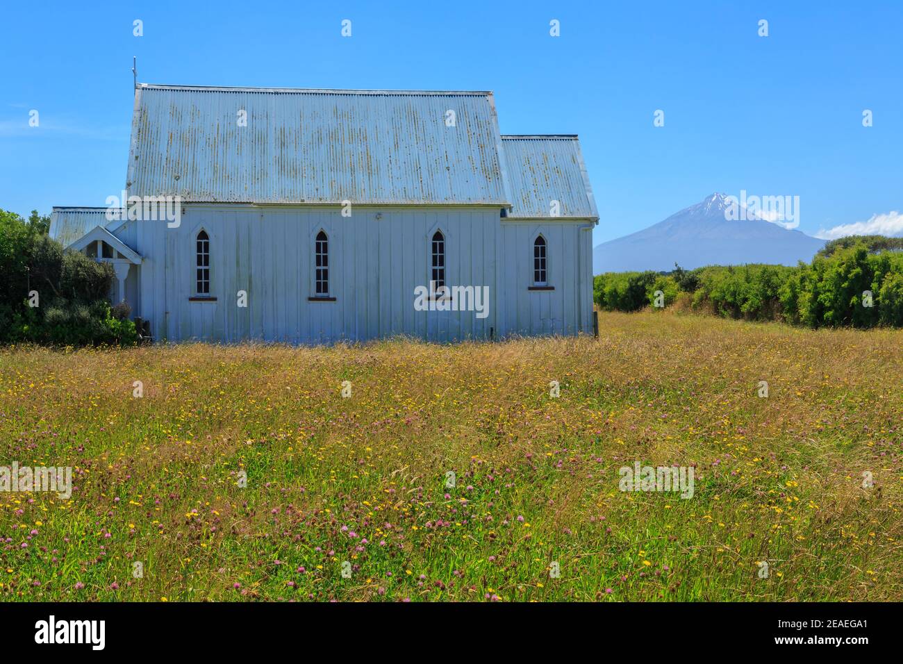 The historic wooden St. John's Anglican Church (1893), Otakeho, New Zealand, with Mount Taranaki in the background Stock Photo