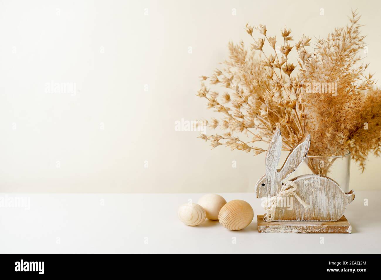Rustic Easter Decorations with wooden rabbit, eggs and pampas grass, copy space Stock Photo