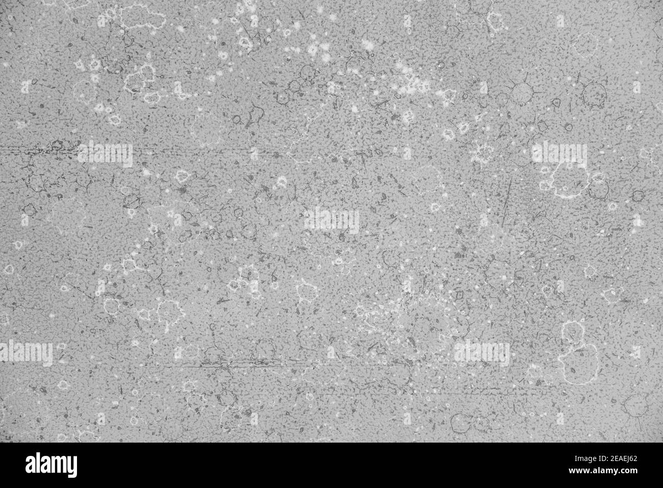 Gray loose acrylic paint texture with white and dark stains. Background