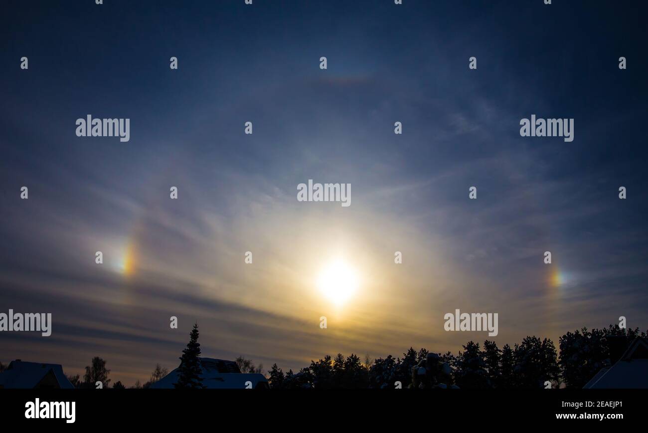 Rainbow around sun is called sundogs also known as parhelion, parhelia. Rare weather effect in winter in cold weather. Sun reflecting from ice crystal Stock Photo