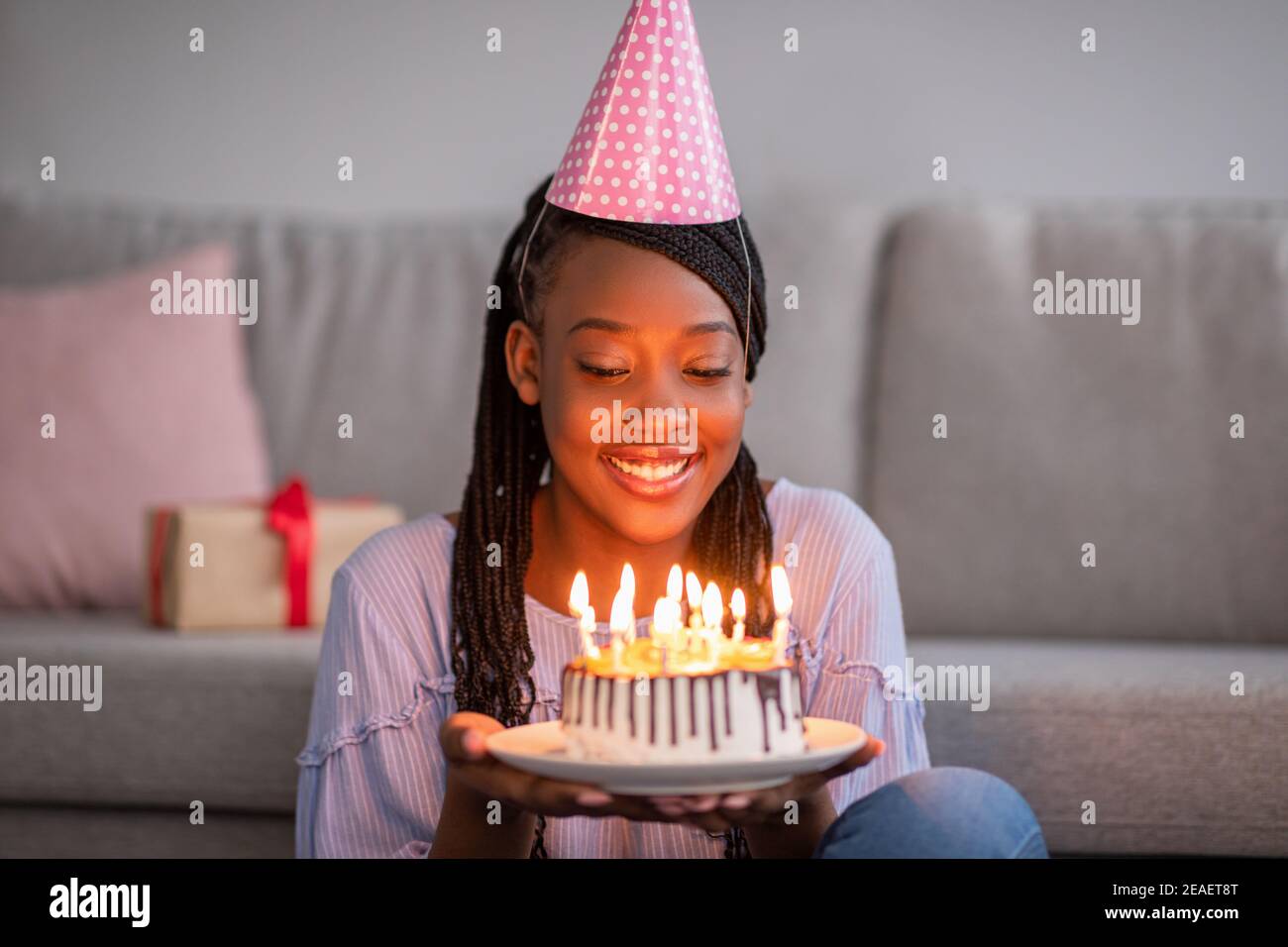 Happy african birthday woman holding festive cake with lightened candles Stock Photo