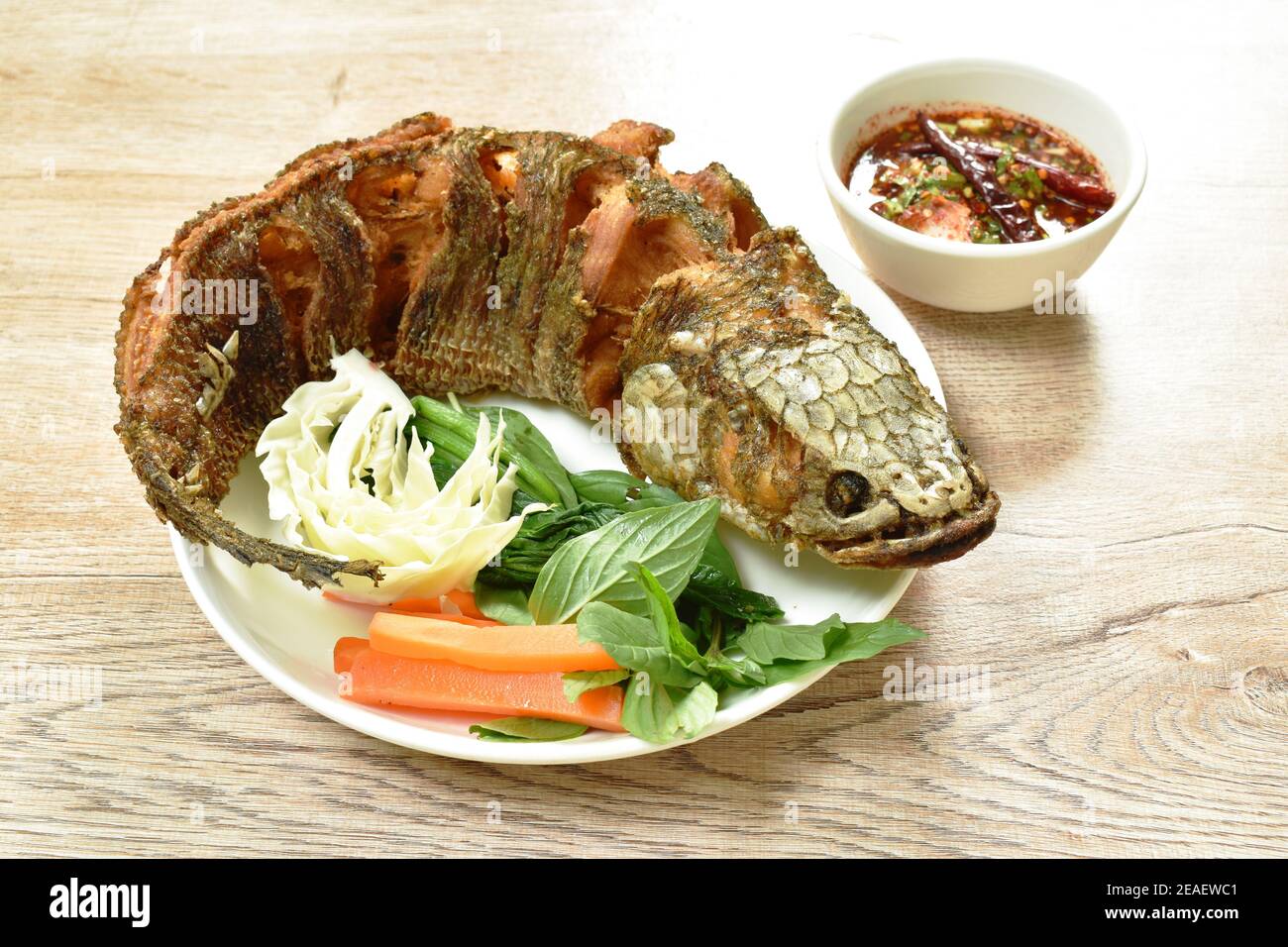 deep fried striped snake head fish with salt eat couple vegetable and