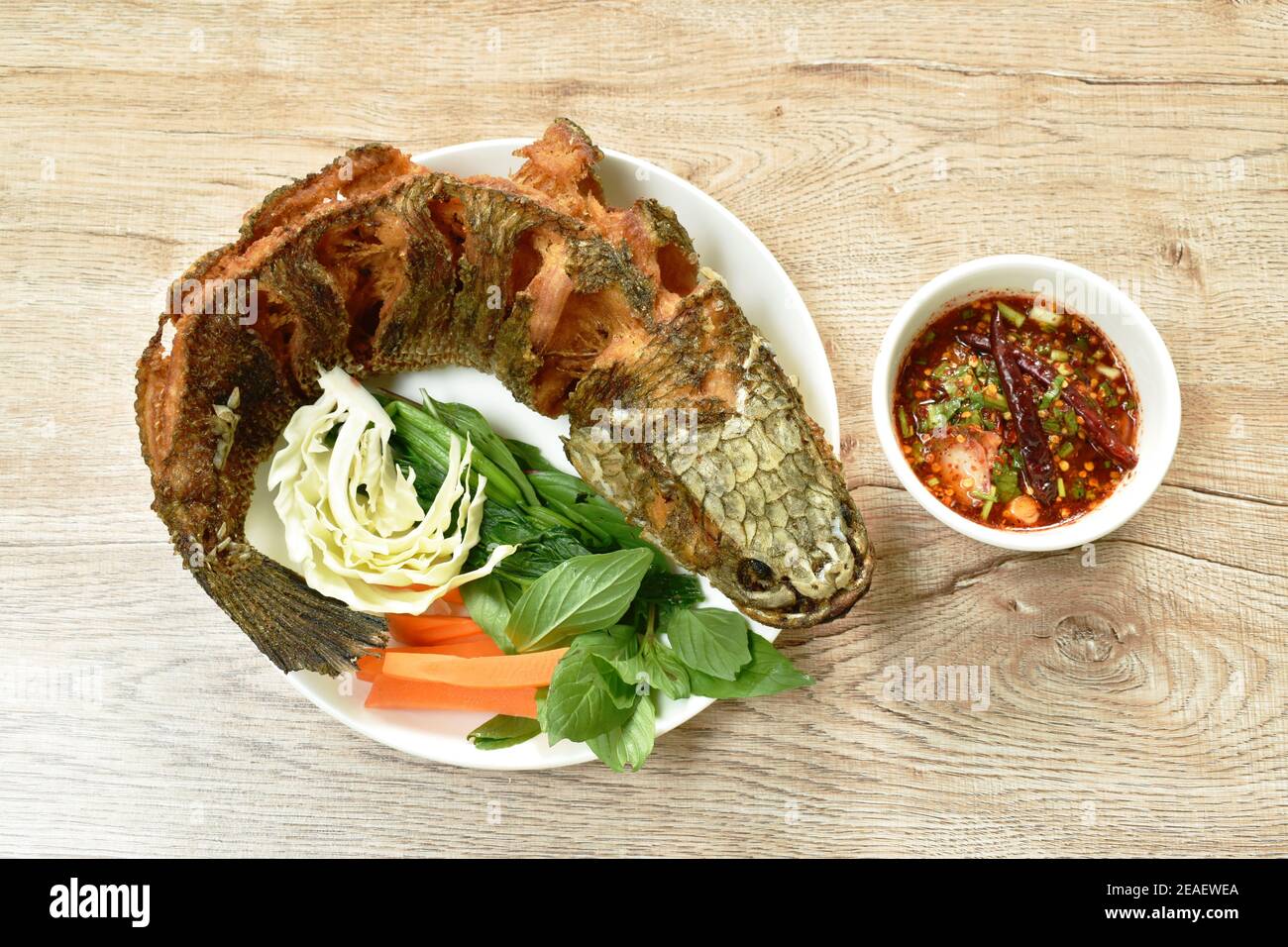 deep fried striped snake head fish with salt eat couple vegetable and