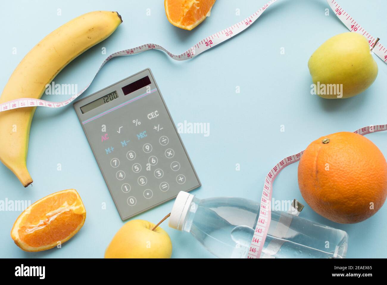 Calculator with numbers 1200, bottle of water, measuring tape and fruits on  blue background. Healthy eating concept - calculate daily nutrition intake  Stock Photo - Alamy
