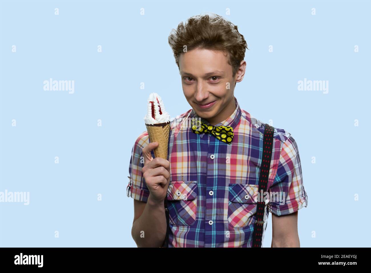 Smiling schoolboy is holding an tasty icecream. Stock Photo
