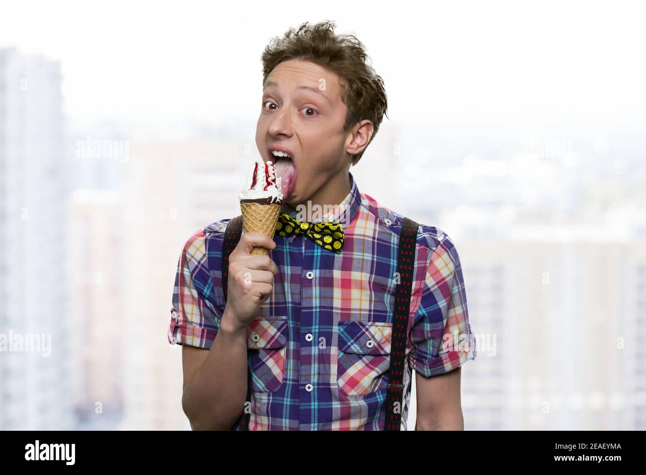 Schoolboy is licking white icecream. Stock Photo
