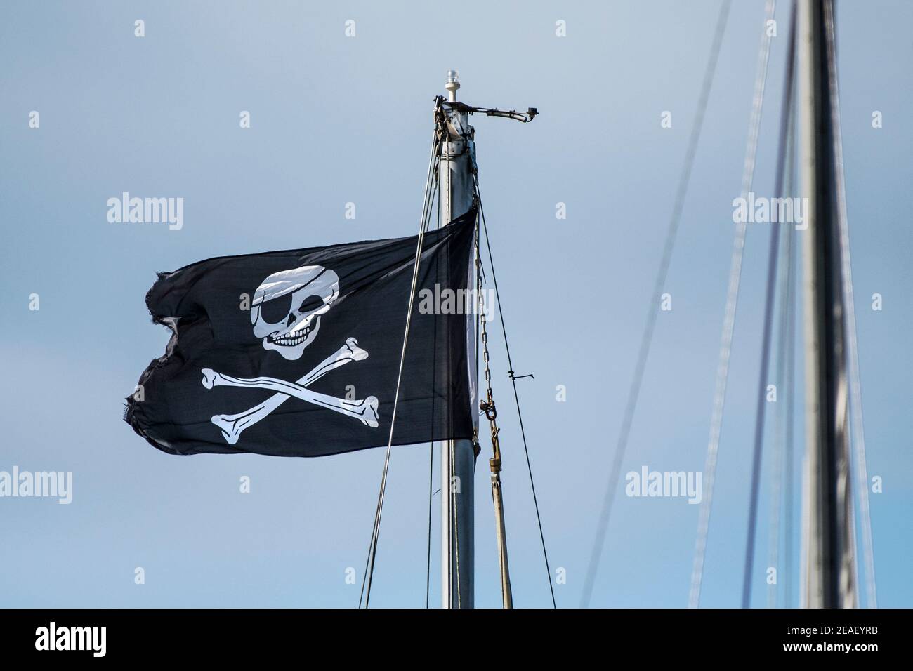 A Skull and Crossbones flag flying from the mast of a boat Stock Photo Alamy