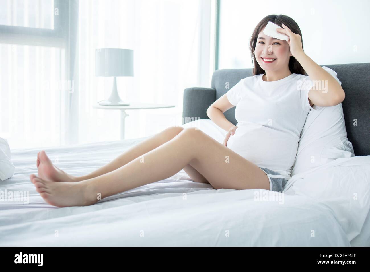 Tired pregnant woman wiping sweat Stock Photo Alamy