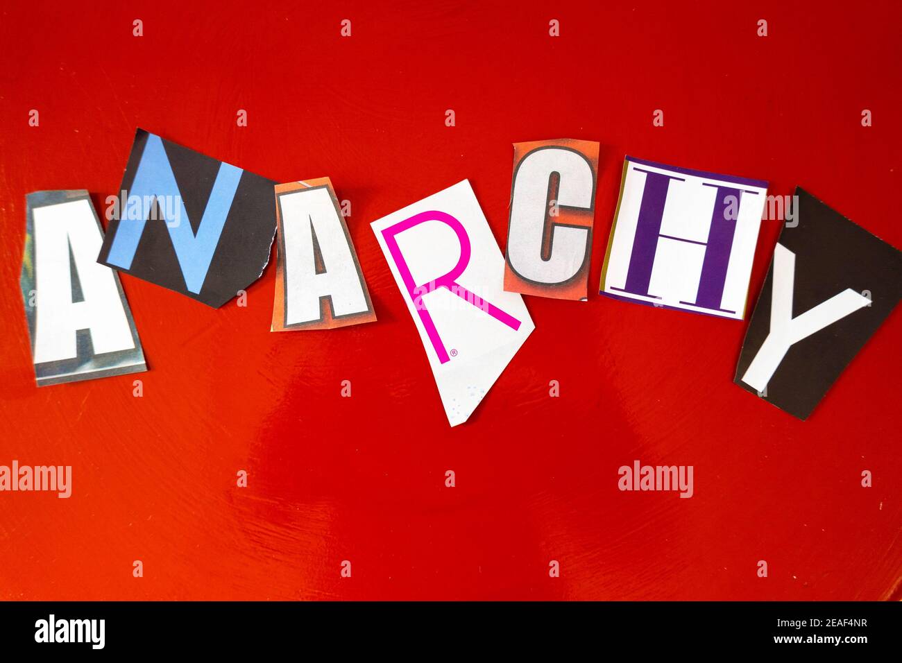 The Word 'ANARCHY' using cut-out paper letters in the ransom note effect typography on a Red Background Stock Photo
