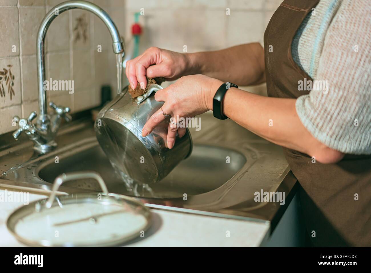 Women washing cooking utensils hi-res stock photography and images - Alamy