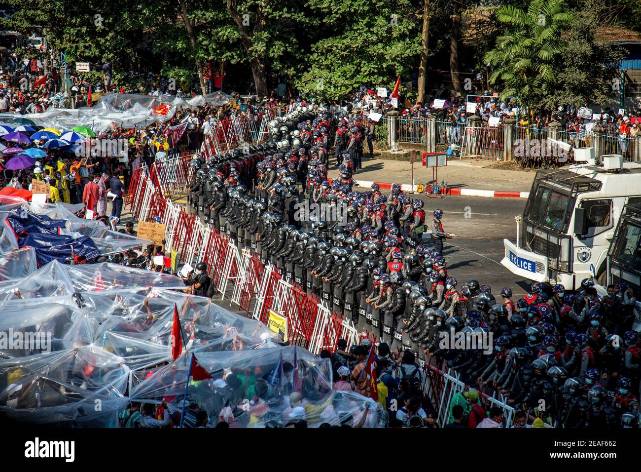 Protesters cover themselves with plastic papers and umbrellas as police force warns them to either disperse or to be water sprayed in Hledan during the fourth day of protests against the military coup. Thousands of people took to the streets of Yangon on the fourth day of protest against the military coup and demanded the release of Aung San Suu Kyi. Myanmar's military detained State Counsellor of Myanmar Aung San Suu Kyi on February 01, 2021 and declared a state of emergency while seizing the power in the country for a year after losing the election against the National League for Democracy ( Stock Photo