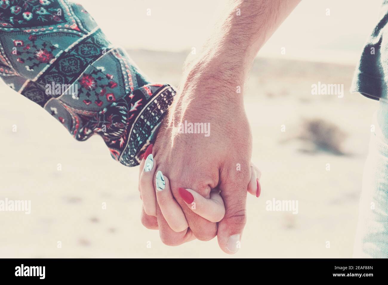 Close up of caucasian hands holding with love and relationship outdoor - young and adult man and woman couple concept - together forever boyfriend gir Stock Photo