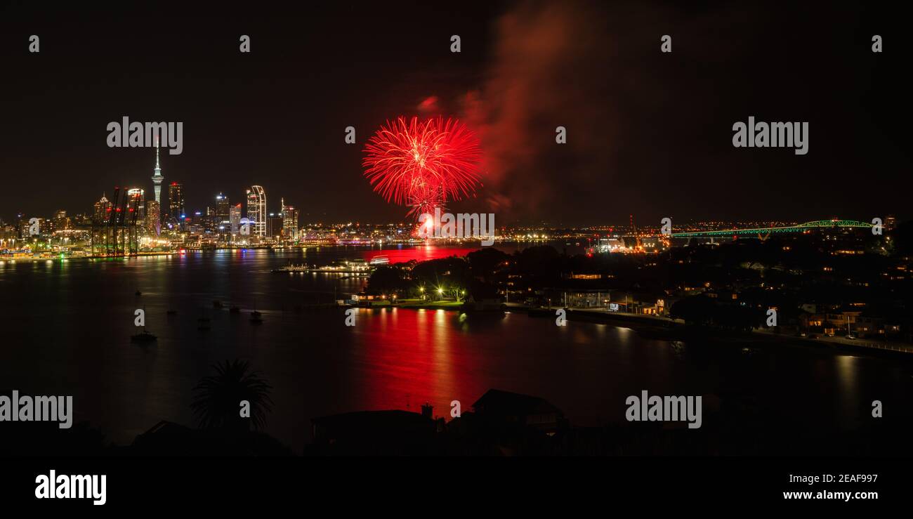 Auckland dazzled by fireworks display with Sky Tower on the left side and Harbour bridge illuminated on the right side. Taken at North Head, Devonport Stock Photo