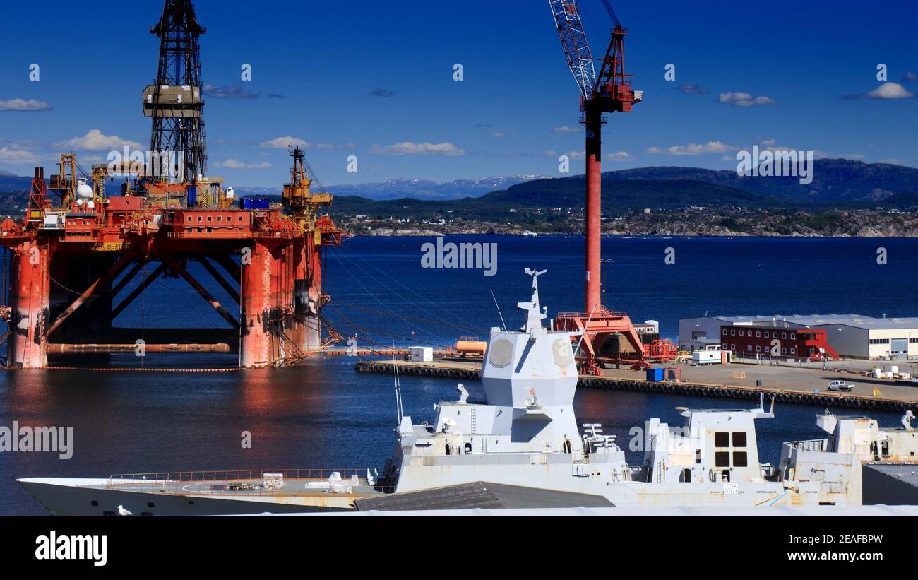 AGOTNES, NORWAY - JULY 24, 2020: Offshore drilling rig maintenance in Agotnes near Bergen, Norway. In foreground: HNoMS Helge Ingstad navy frigate wai Stock Photo