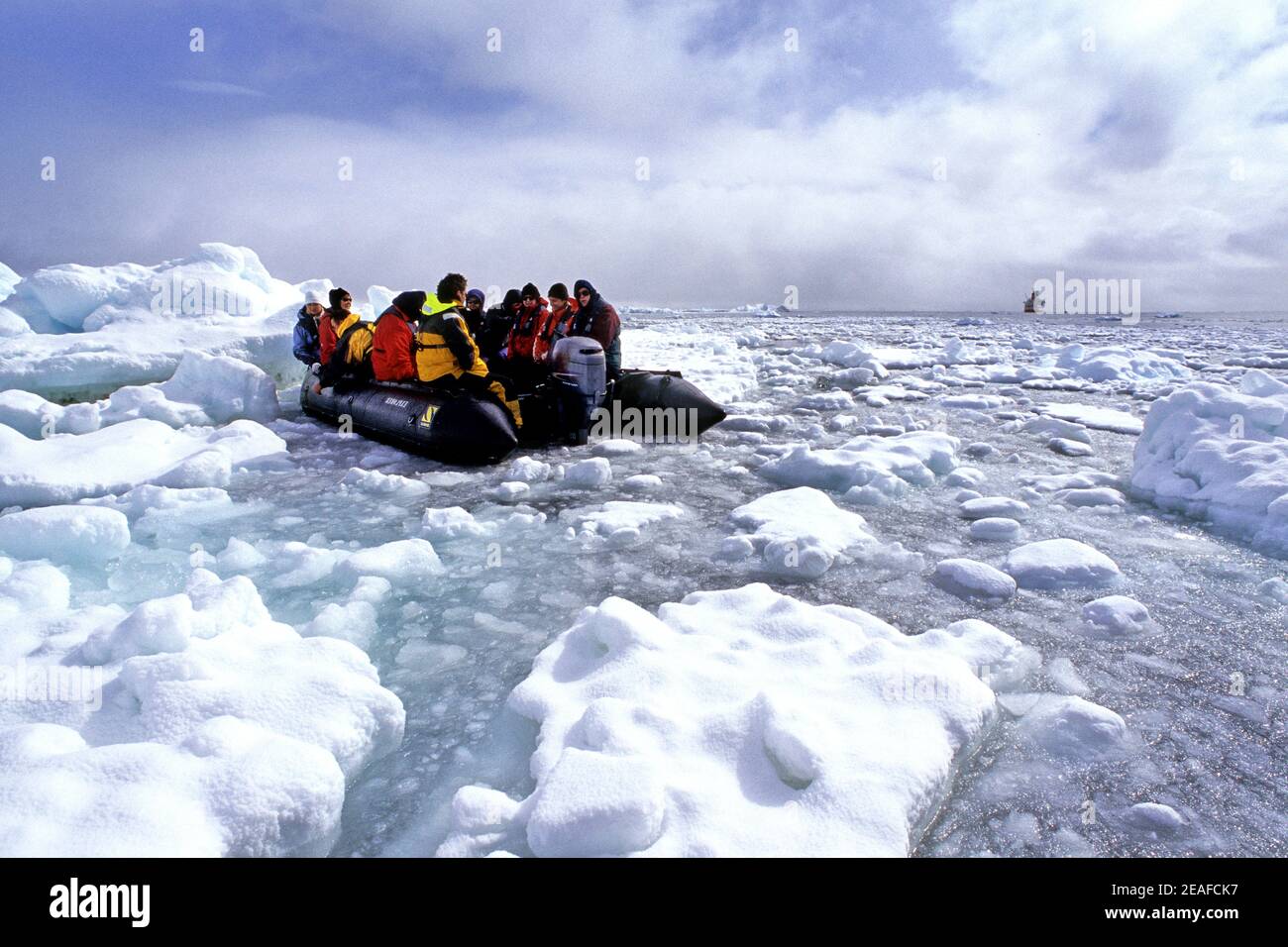 Passengers from the expeditionship in a zodiac looking and studying the pack ice on Antarctica Stock Photo