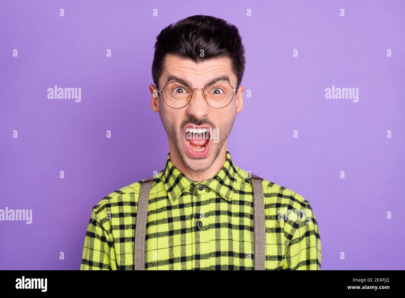 Photo portrait of enraged screaming man isolated on vivid violet colored background Stock Photo
