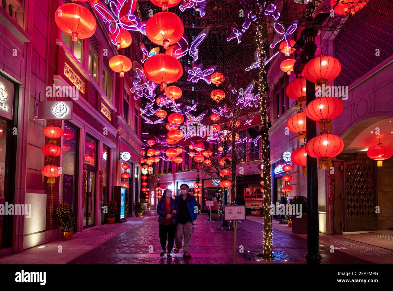 January 31, 2021, Hong Kong, China: A couple wearing masks walks under hundreds of red lanterns hanged from the ceiling at Lee Tung Avenue in Hong Kong to celebrate the Chinese Lunar New Year festival and the year of the Ox. (Credit Image: © Miguel Candela/SOPA Images via ZUMA Wire) Stock Photo