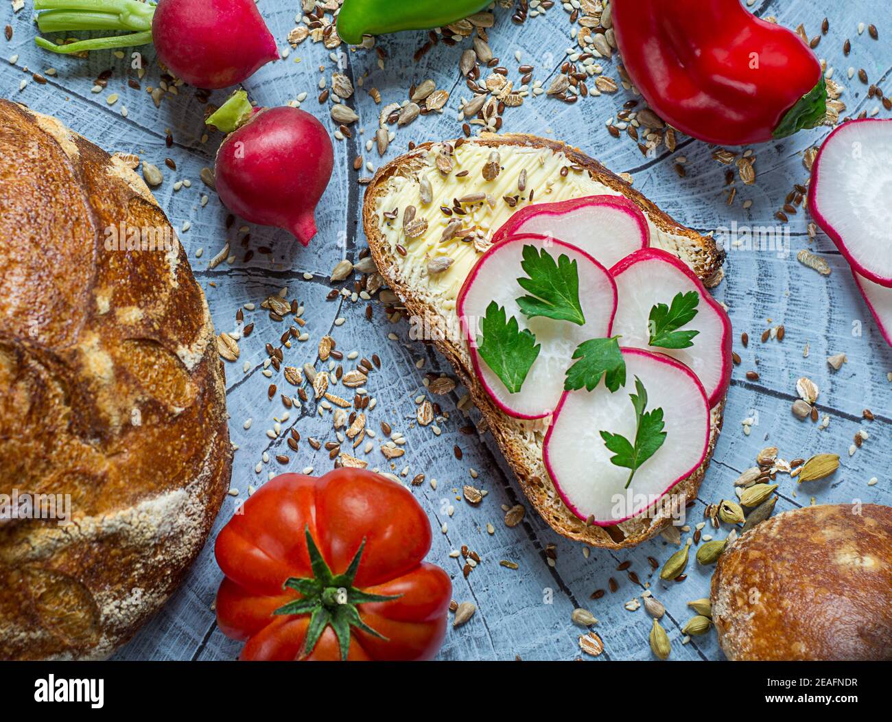 Slice of artisan bread with cream cheese, radish, butter decorated with