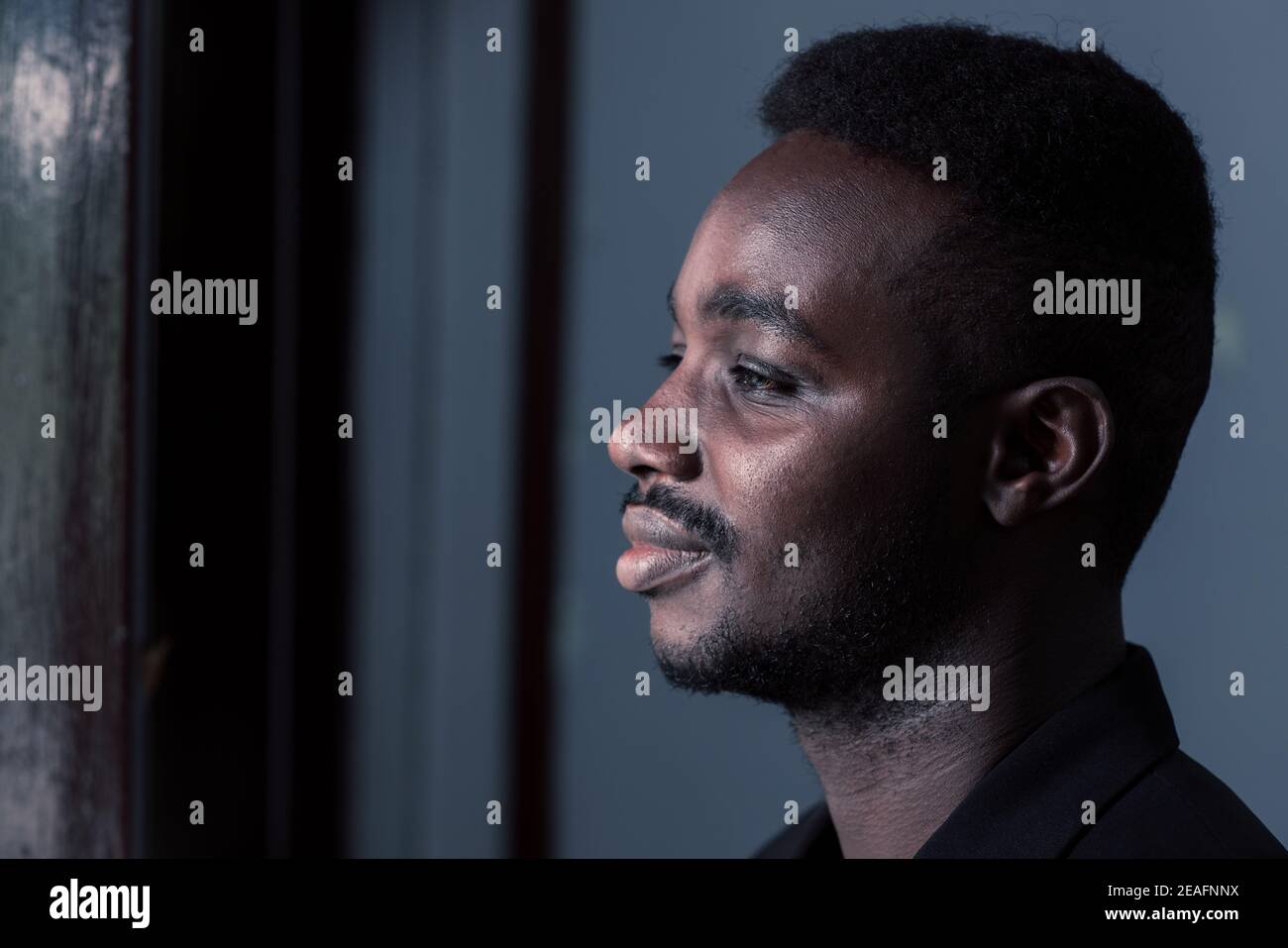 Sad african man in dark room , Low key style Stock Photo