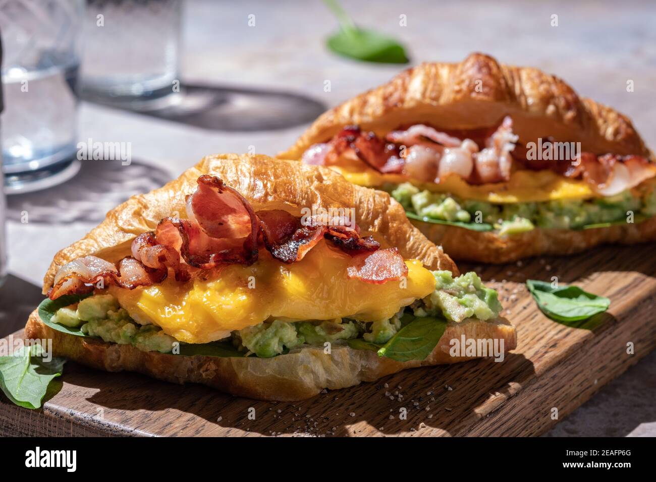 https://c8.alamy.com/comp/2EAFP6G/croissant-sandwich-breakfast-with-scrambled-egg-crispy-bacon-and-mashed-avocado-2EAFP6G.jpg